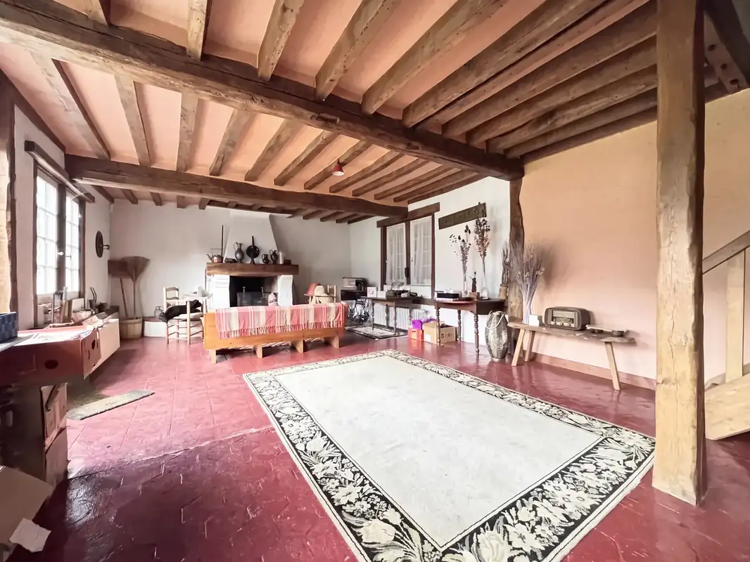 La grande pièce de la seconde maison, son tapis et ses poutres